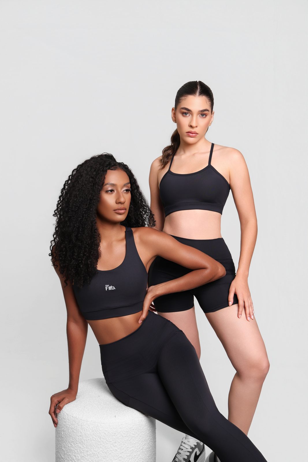 Duas mulheres com conjuntos fitness pretos da Club Fitb.