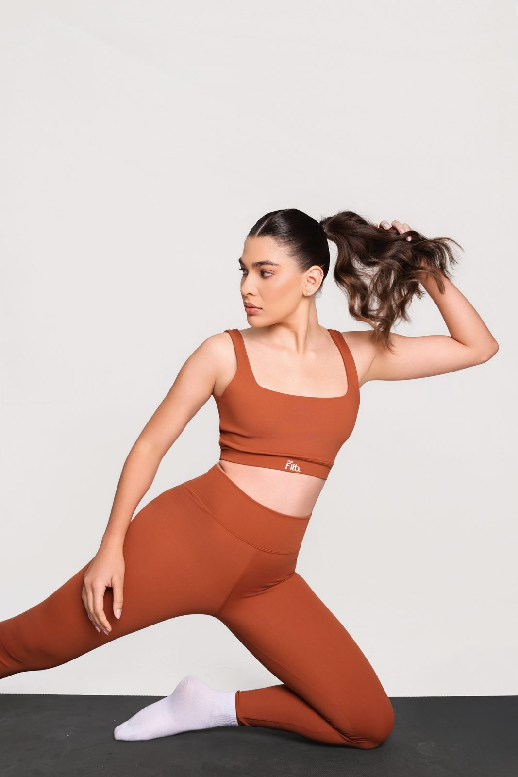 Mulher com conjunto fitness terracota em movimento